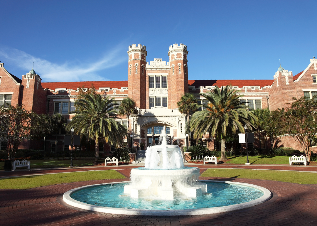 An ornate red and white brick building at Florida State University with a water fountain in the foreground.