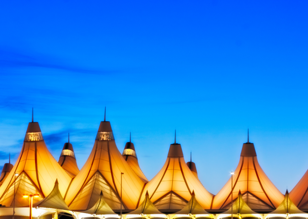 A close up of a distinctive, tent-like roof of the Denver airport building lit intended to mimic the snow-capped peaks of the Rocky Mountains. 