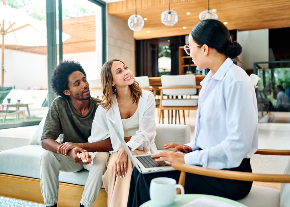 A financial advisor talking to a couple in their home.