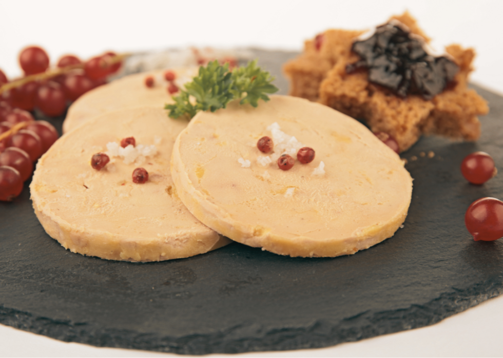 Three slices of foie gras on a cutting board.