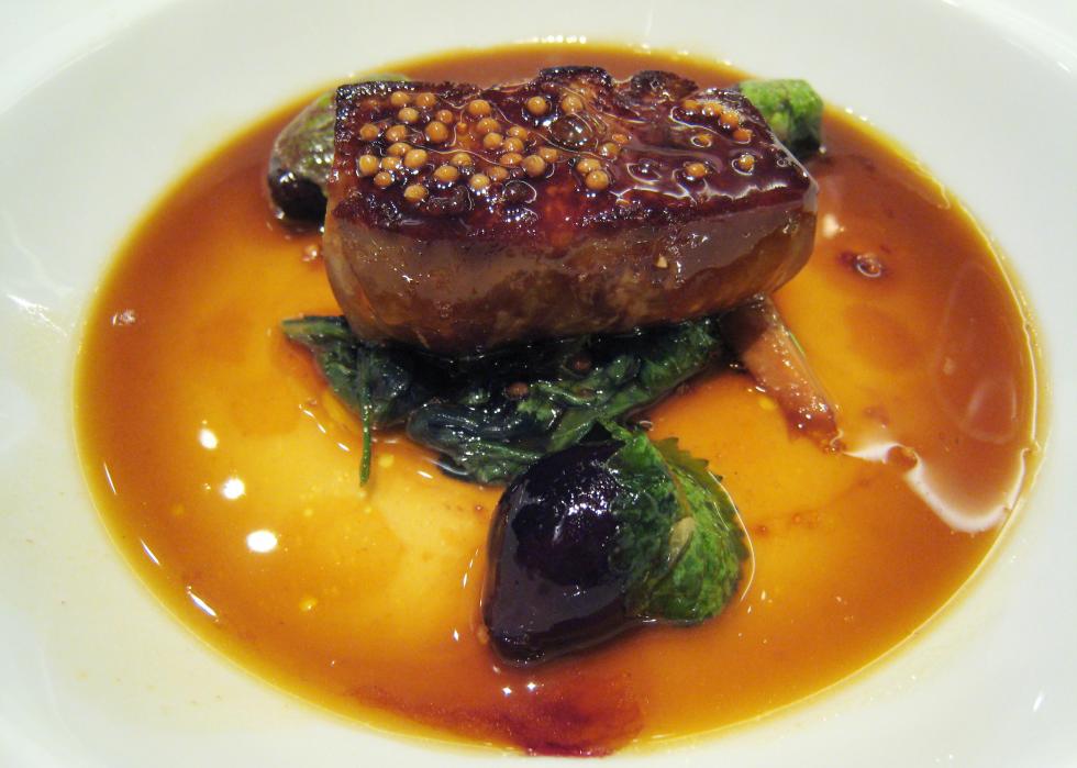 A dish of foie gras drenched in sauce.