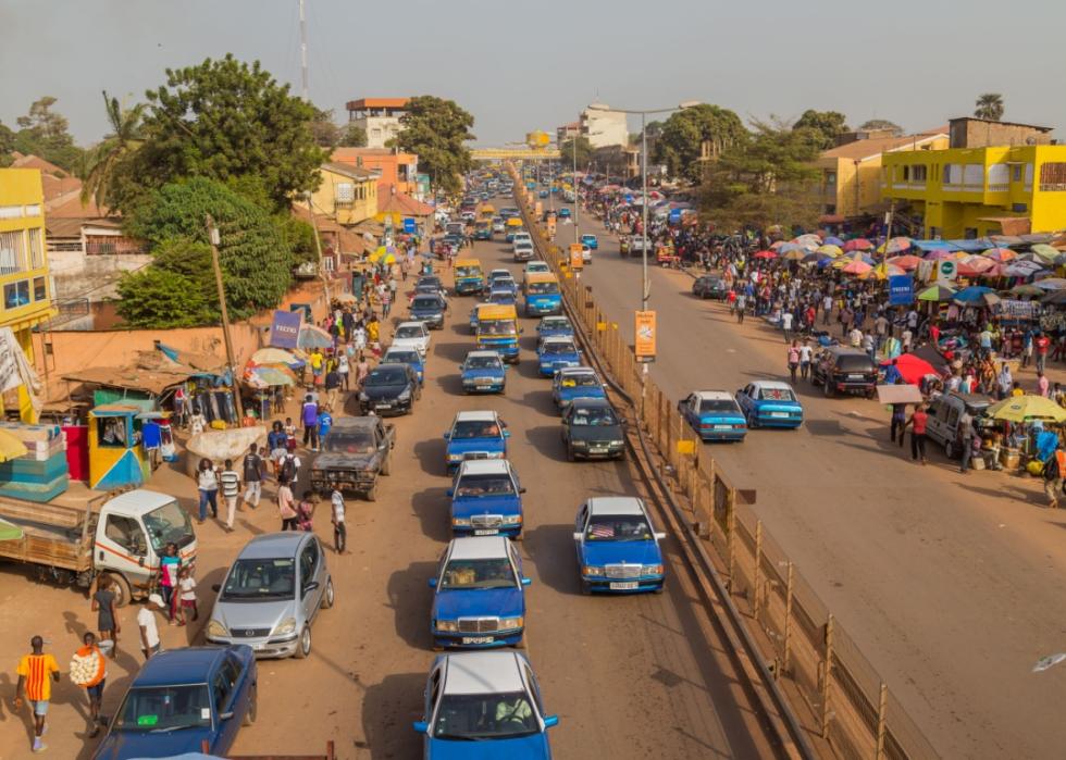 Street scene in the city of Bissau with cars in a road.
