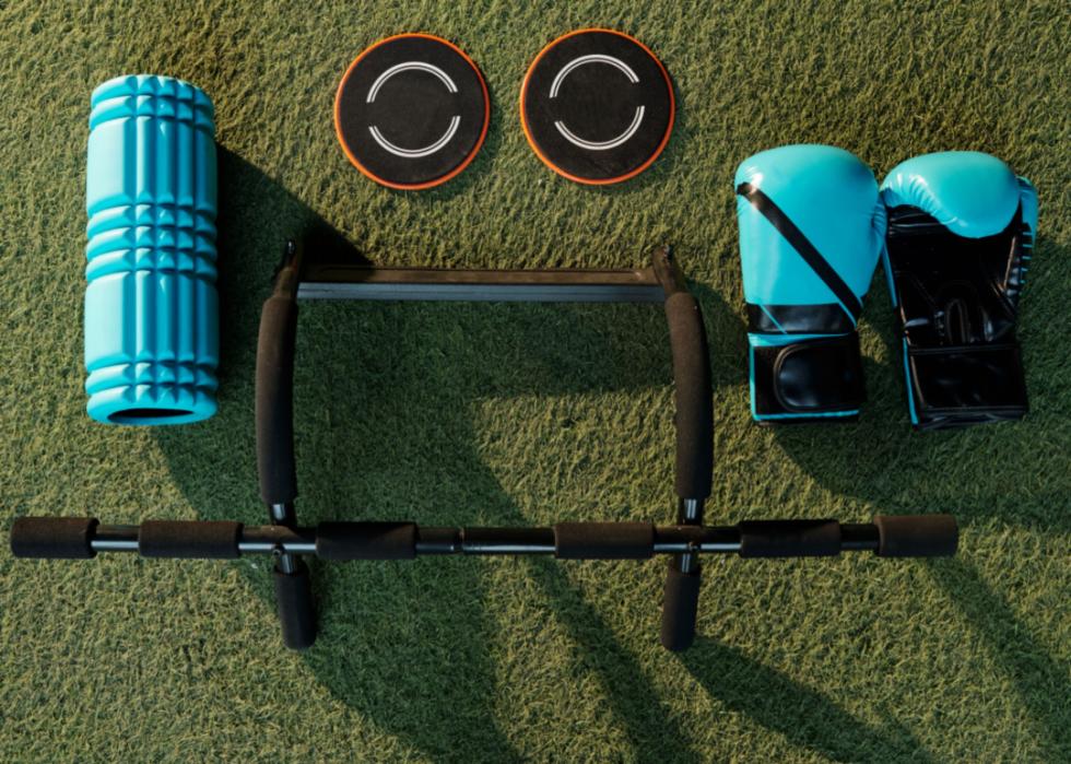 Various workout equipment, including a pull-up bar, sliders, a foam roller, and boxing gloves.