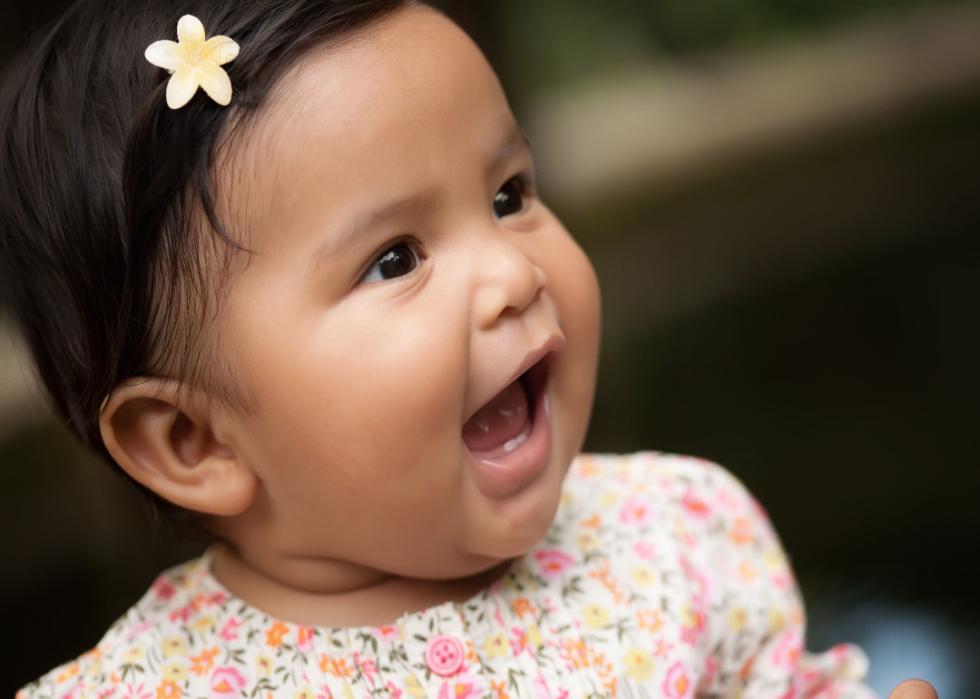 A closeup of a Hispanic baby girl smiling. 