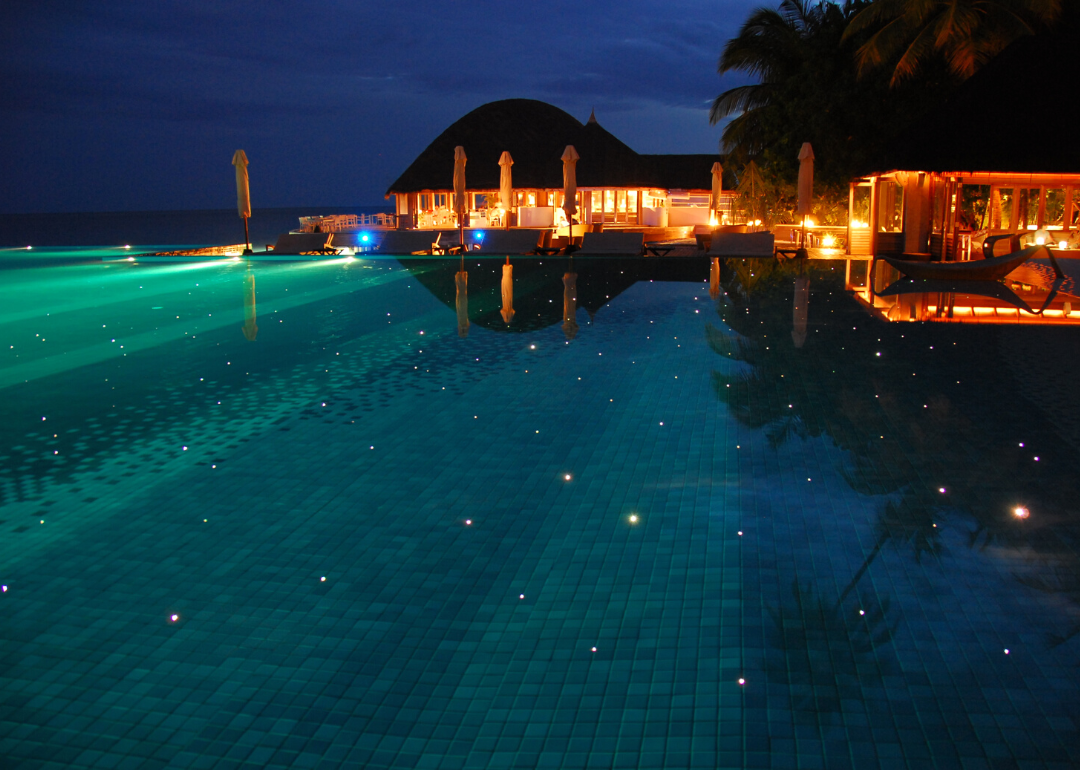 An evening view of the pool at Hotel Huvafen Fushi illuminated from within by fiber-optic lights.
