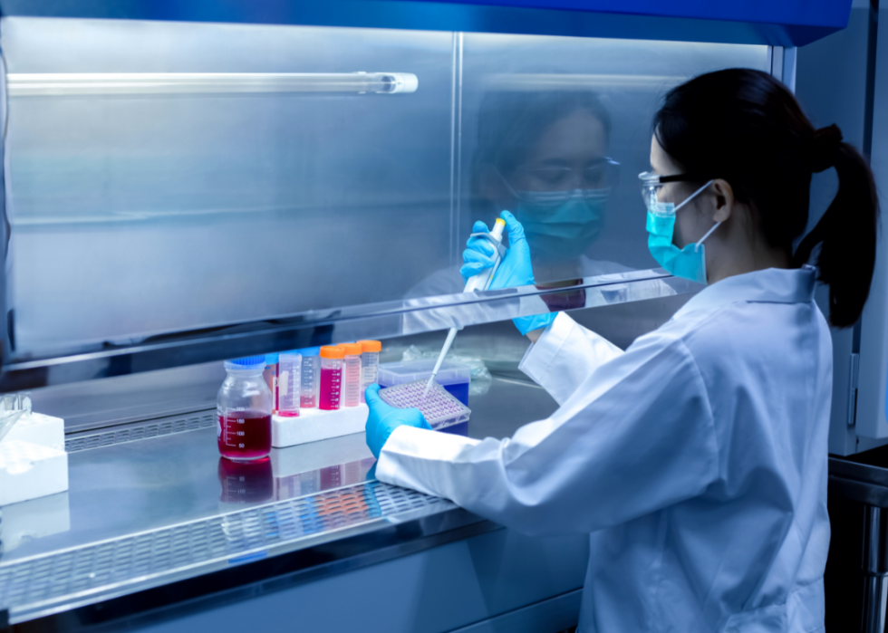 A scientist working with liquid in test tubes.