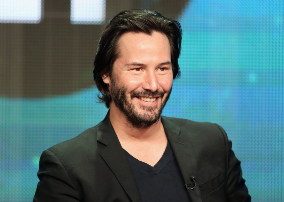 Keanu Reeves smiles at event.