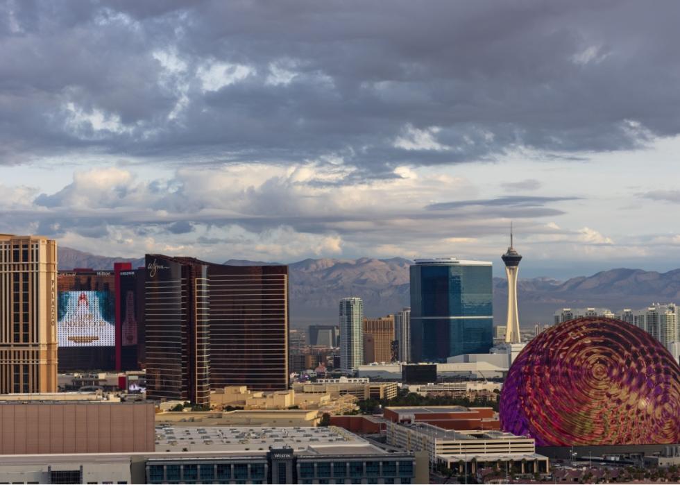 An aerial view of city skyline with high-rise buildings. Mountains in the background.