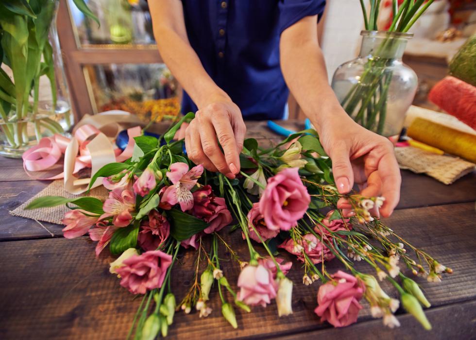 Florist working with flowers in a workshop.