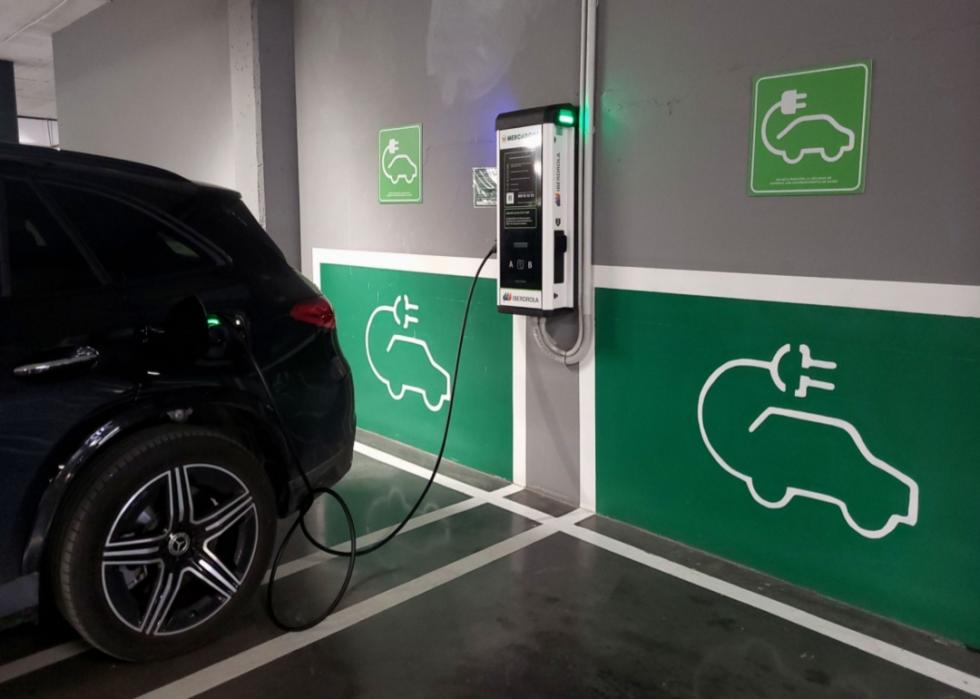 A Mercedes SUV plugged into a charging station.