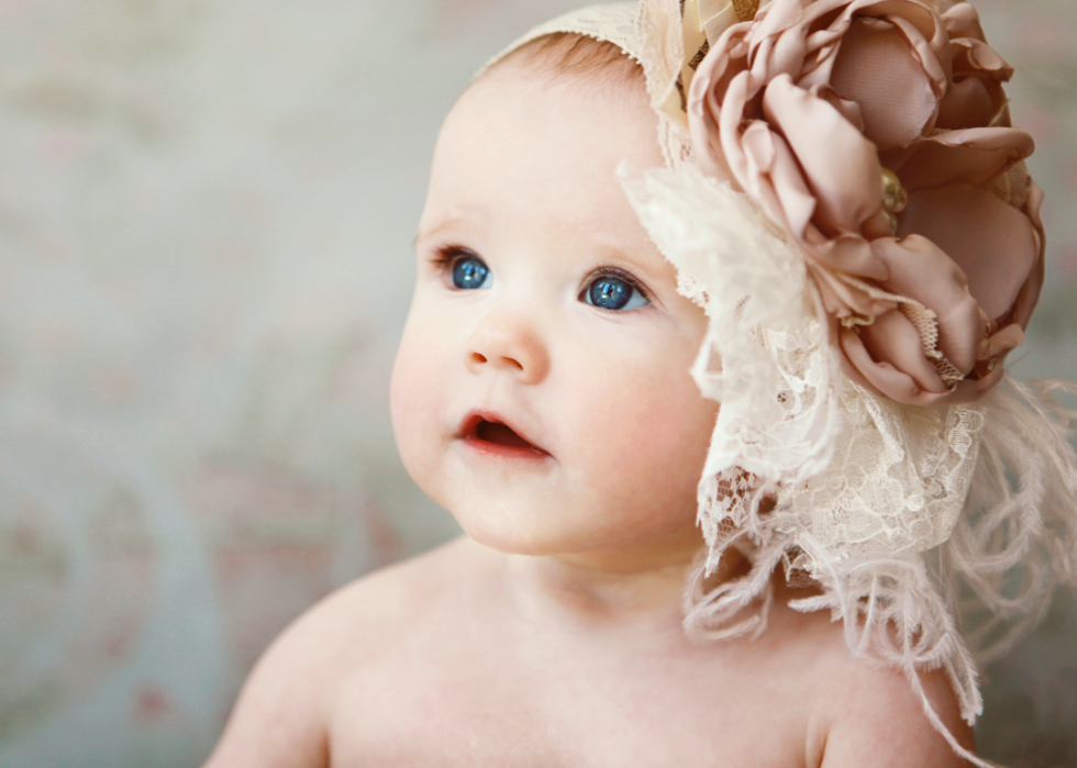A baby girl with a rose band on her head. 