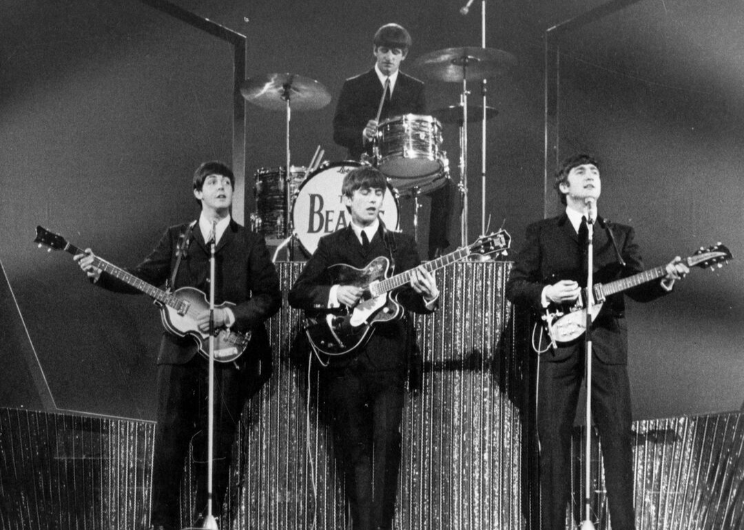 The Beatles performing onstage.