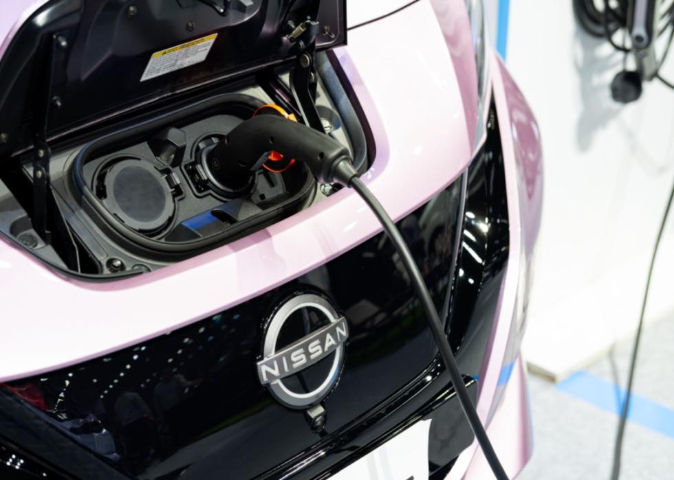 Close up of a pink Nissan electric vehicle charging. 