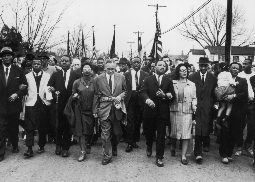 Martin Luther King and his wife Coretta Scott King lead the march. Among those pictured are John Lewis, Reverend Ralph Abernathy, Ruth Harris Bunche, Ralph Bunche, and Hosea Williams.