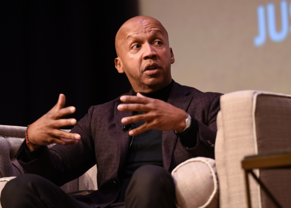 Bryan Stevenson, seated on stage, speaks to an audience during a 2020 event at National Museum Of African American History & Culture.