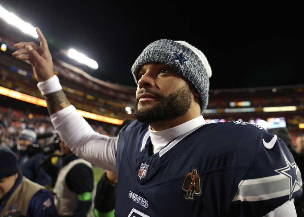 Dak Prescott waving to fans on the field.