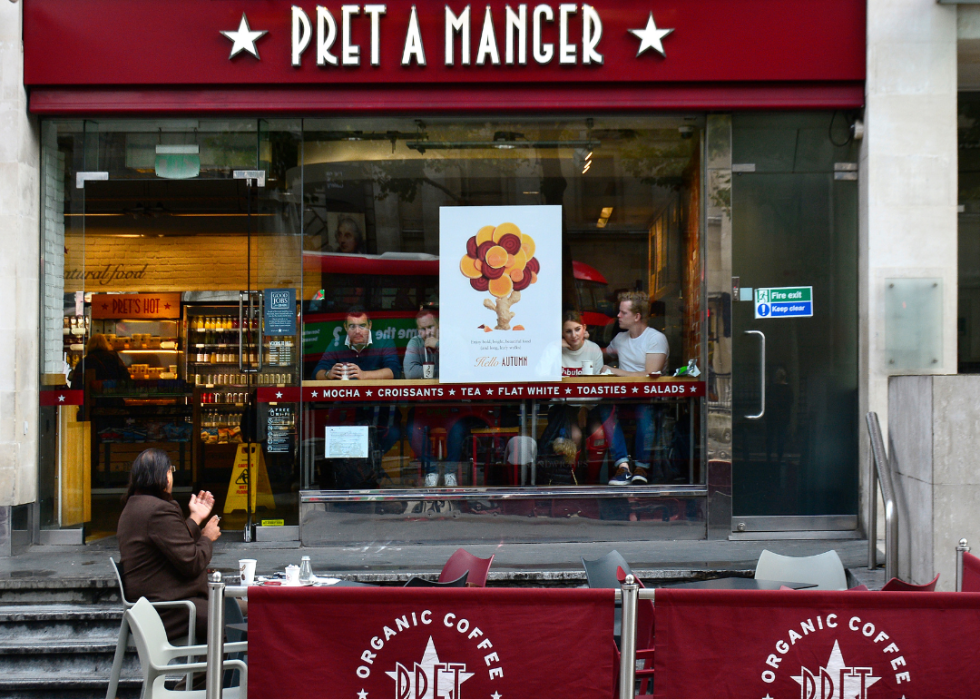 A view from the sidewalk of patrons at Pret A Manger, which has seating out front. 
