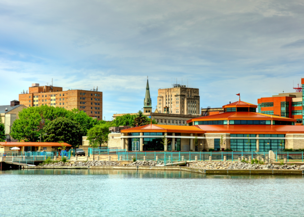 A city's skyline, with a river in the foreground. 