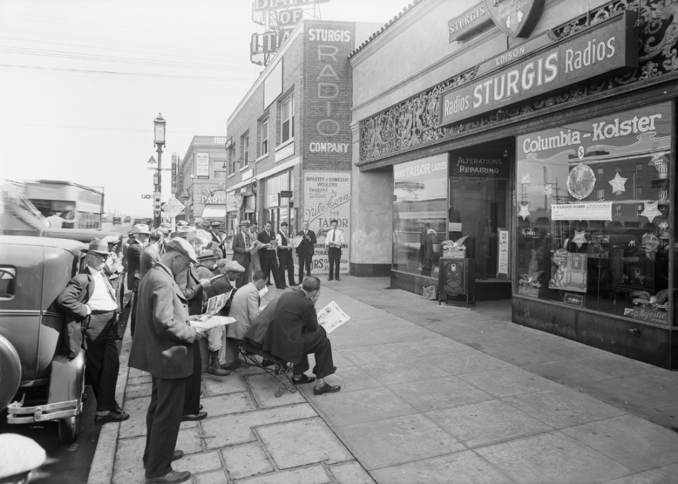 A group of men gather outside a radio store to listen to the world series.