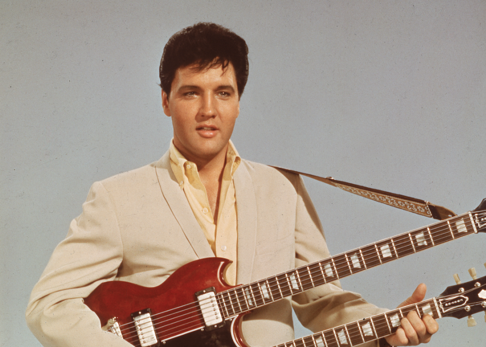 Elvis in a publicitiy still holding a guitar