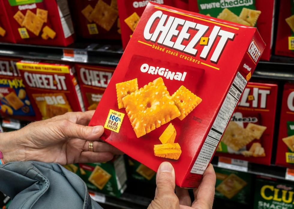 A shopper chooses a box of Cheez-Its in a supermarket.