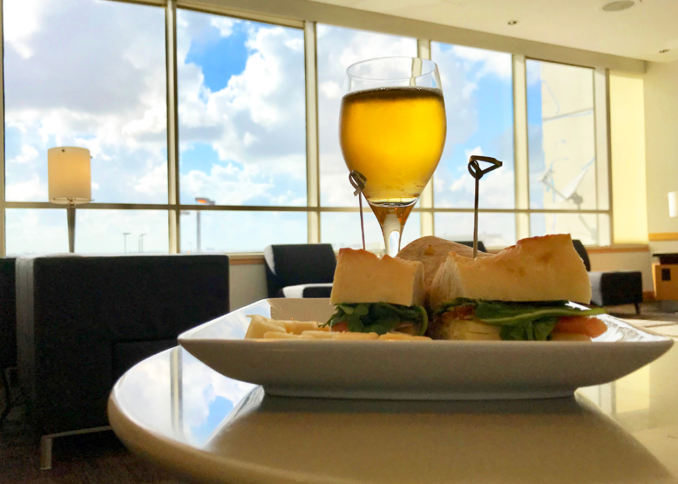 A sandwich and a glass of wine in an airport lounge.