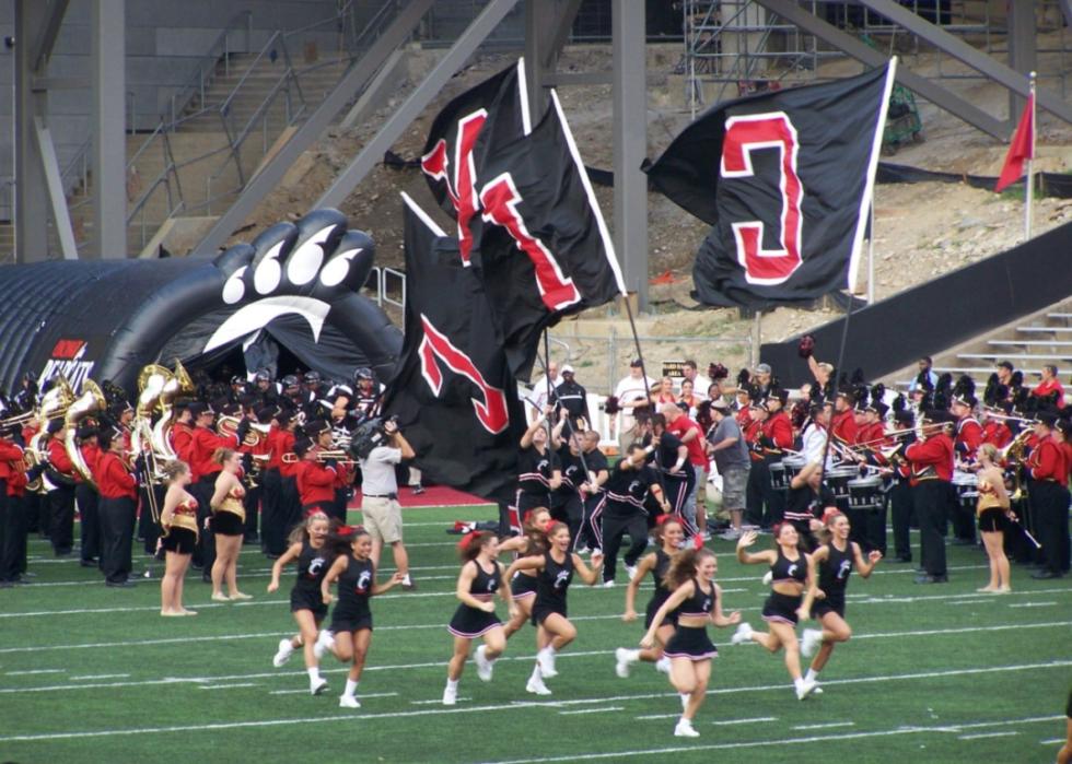 University of Cincinnati cheerleaders running on the field.