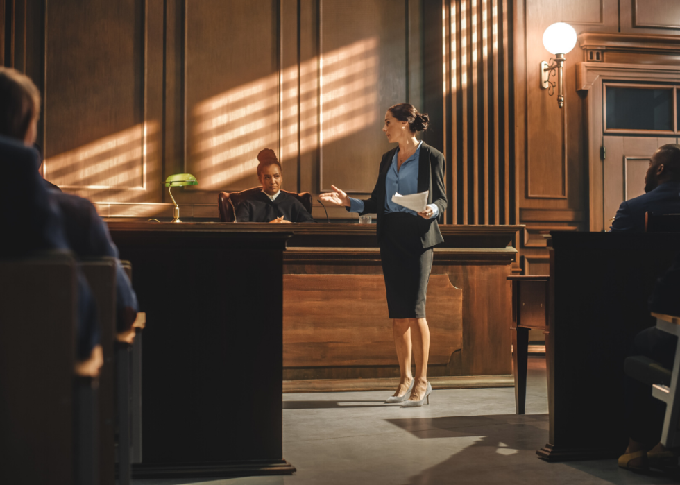A female prosecutor presenting a case to a judge and jury