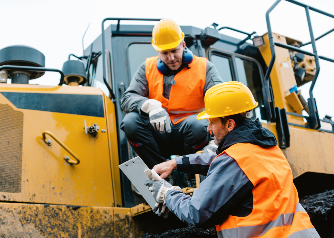 Heavy machinery workers in a discussion.