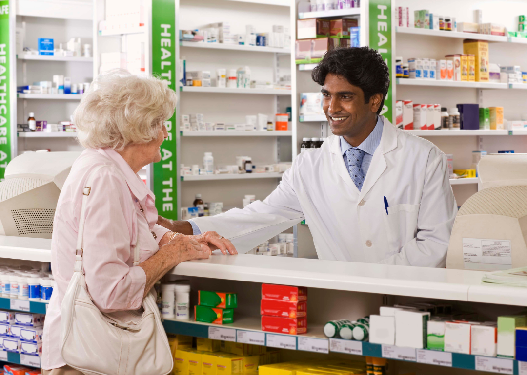 A pharmacist helping an elderly person.