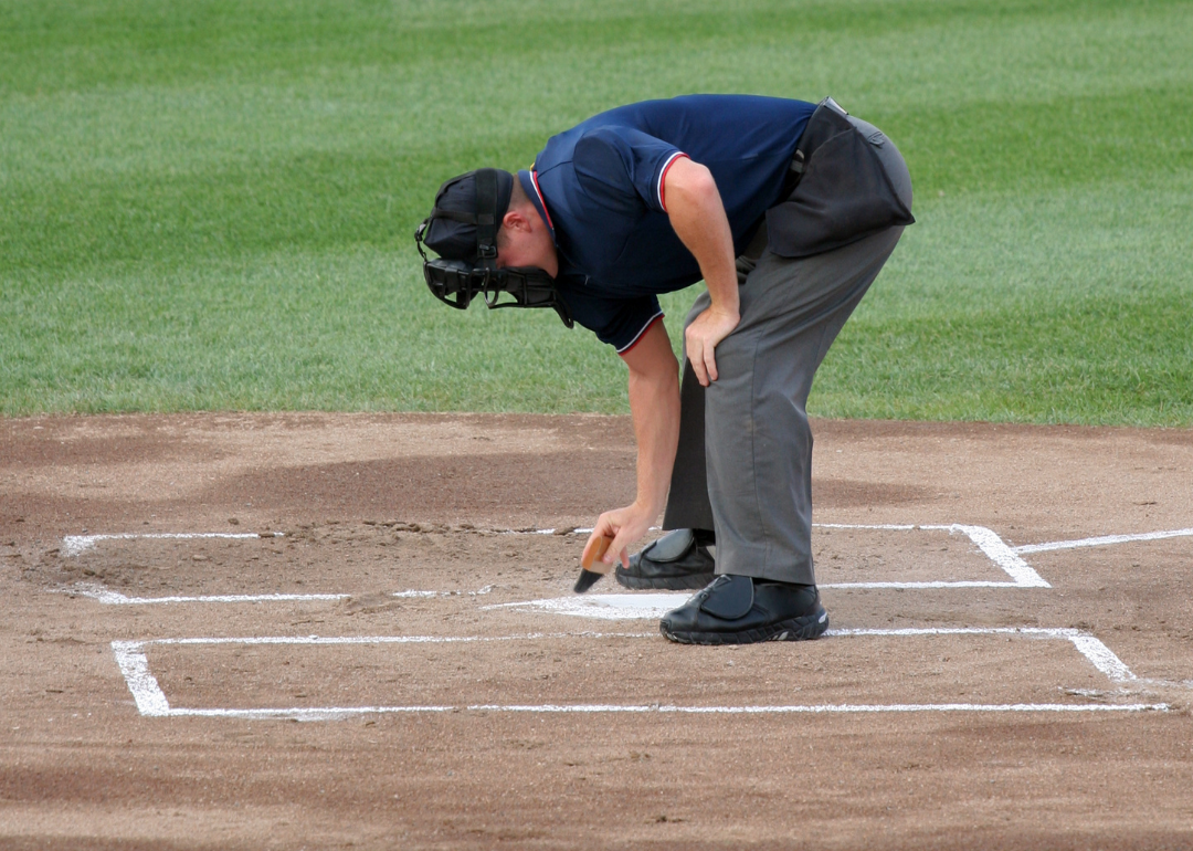 An umpire cleaning home base.