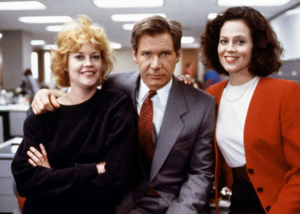 Melanie Griffith, Harrison Ford, and Sigourney Weaver look at the camera during a scene in the film, Working Girl.