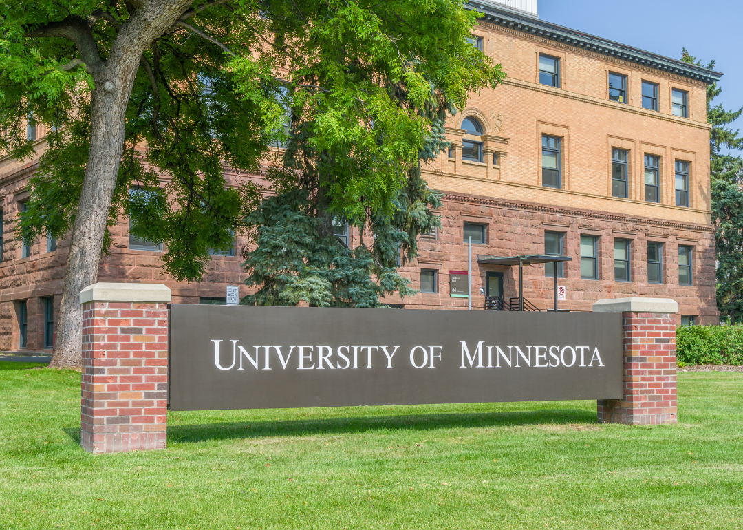 An entrance sign and Wulling Hall on the campus of the University of Minnesota.