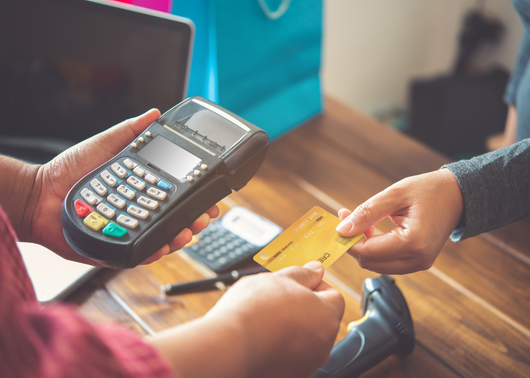 A person in a shop paying with a credit card.