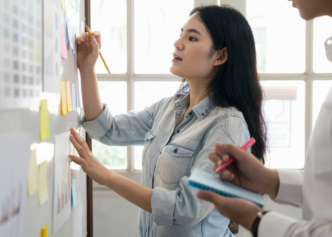 A project manager writing on a white board.