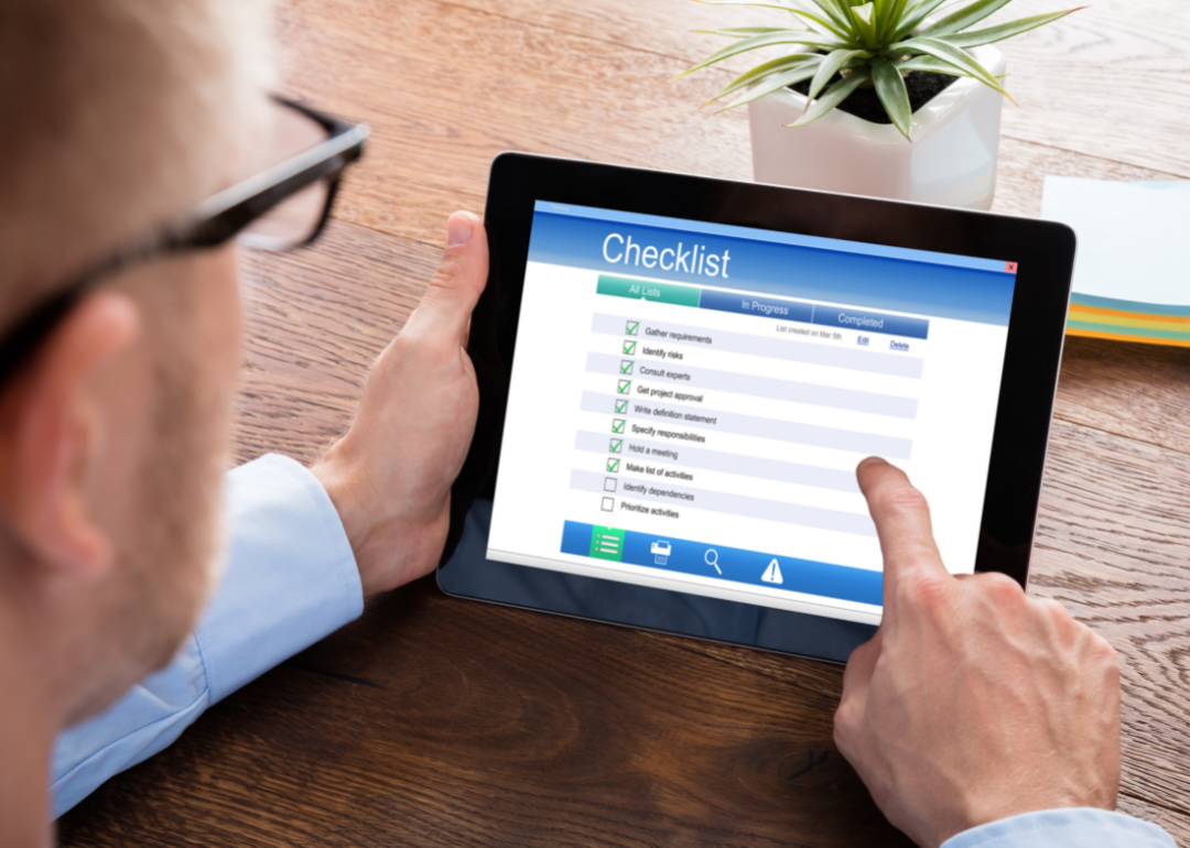 A student looking at a tablet displaying a checklist.