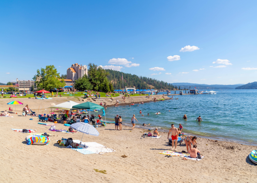 A busy summer day along the sandy beach of the lake at Independence Point in the downtown resort district of rural Coeur d'Alene.