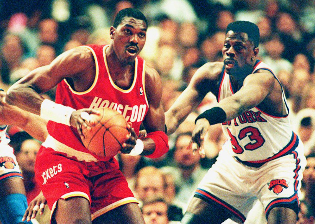 Houston's Hakeem Olajuwon, left, looking to pass the ball under defensive prese fifth game of the sure from the New York Knicks' Patrick Ewing during the NBA Finals at Madison Square Garden.