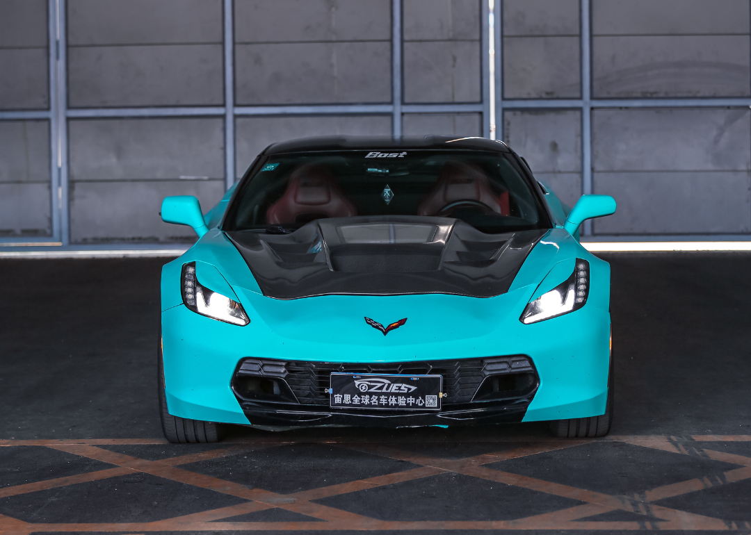 A blue Chevrolet Corvette Z06 SUPER CHARGE P sports car parked in a garage.