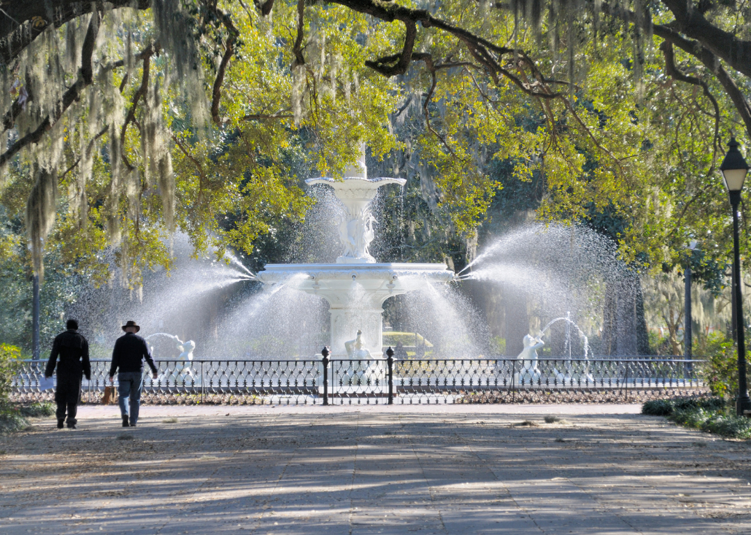 Two people walking in Forsythe Park, in Savannah, Georgia.