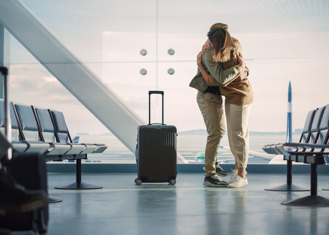 Two people hugging in an airport
