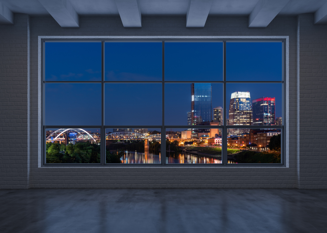 Nashville's skyline at night viewed from a high rise's large windows.