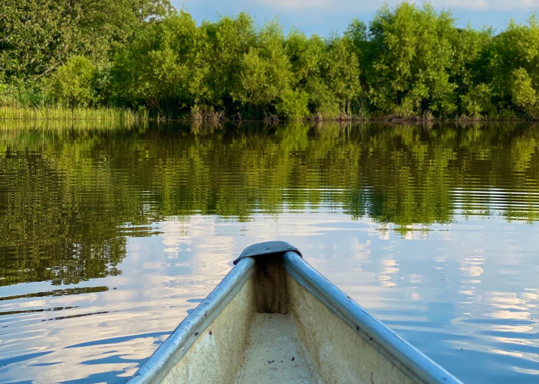 A canoe on a calm lake during a warm day.