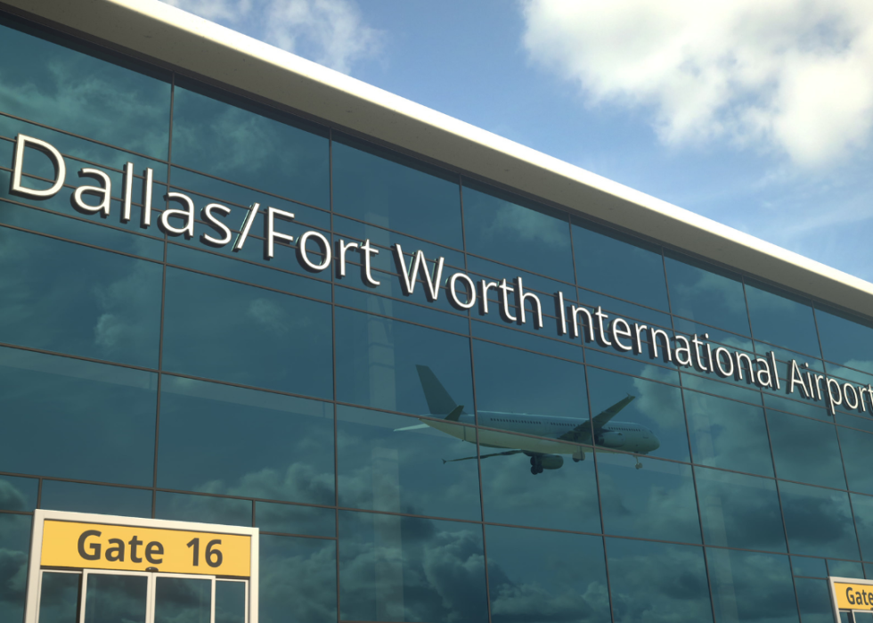 Airplane landing, as viewed in the reflection in the windows of Dallas-Fort Worth International Airport
