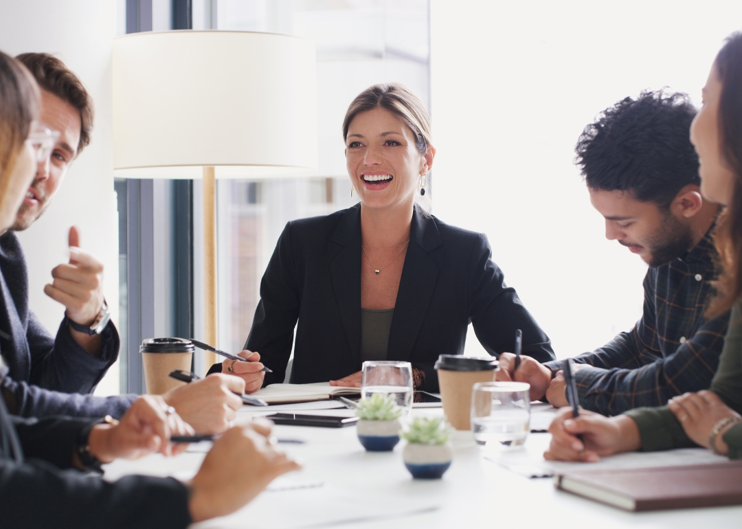 Employees smiling as they collaborate in the workplace