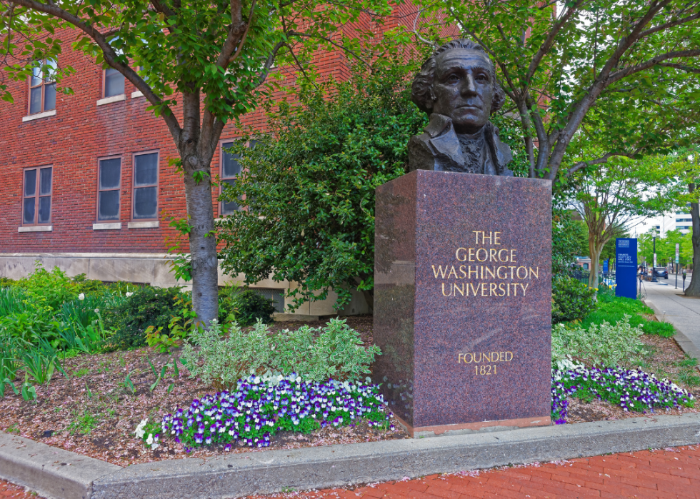 A marble sign with a bust of George Washington on the campus of George Washington University.