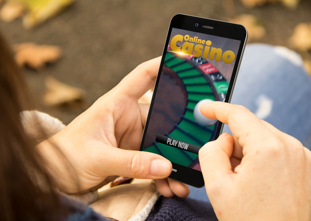 A person at the park using their mobile phone to access an online casino.
