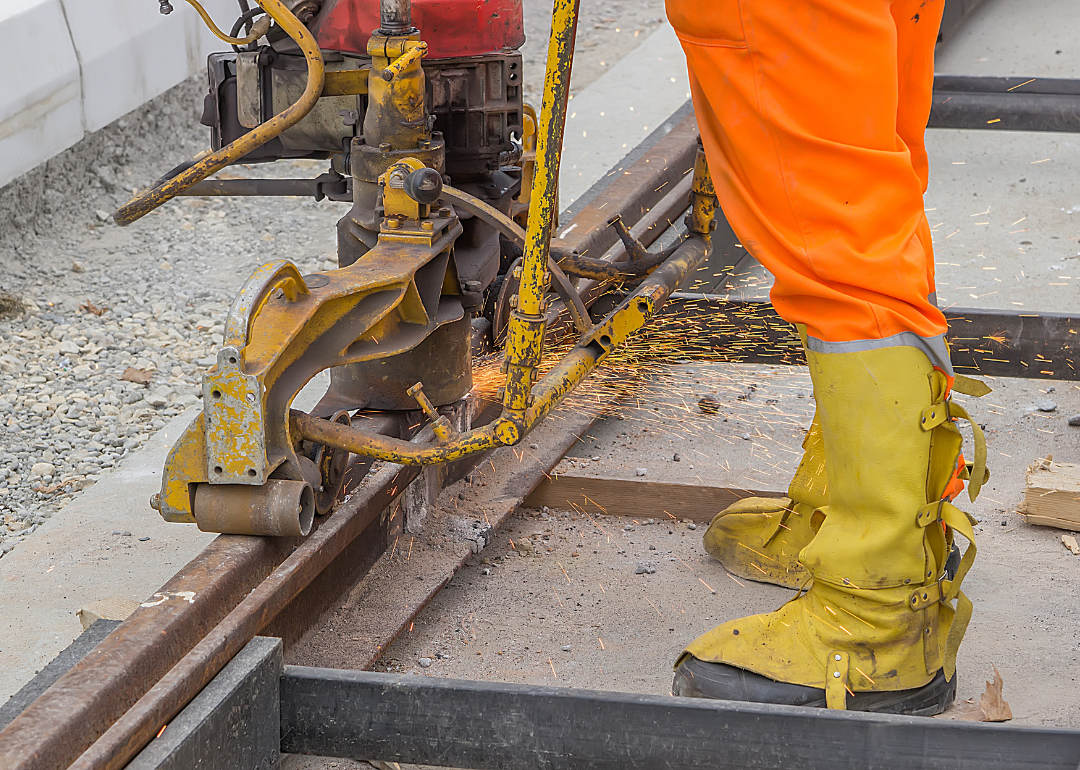 A worker fixes a stretch of rail.