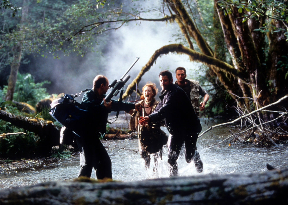 Jeff Goldblum, Julianne Moore, and Vince Vaughn running through water trying to escape danger in The Lost World: Jurassic Park