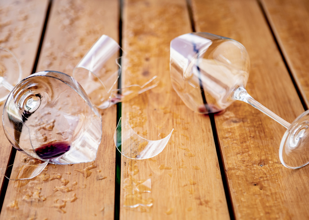 Shattered, broken wine glasses on a wooden table